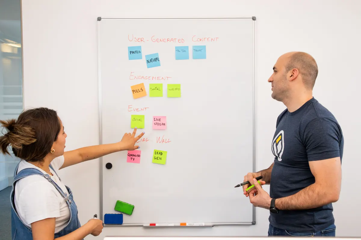 Two team members planning a client's review-response process on a whiteboard